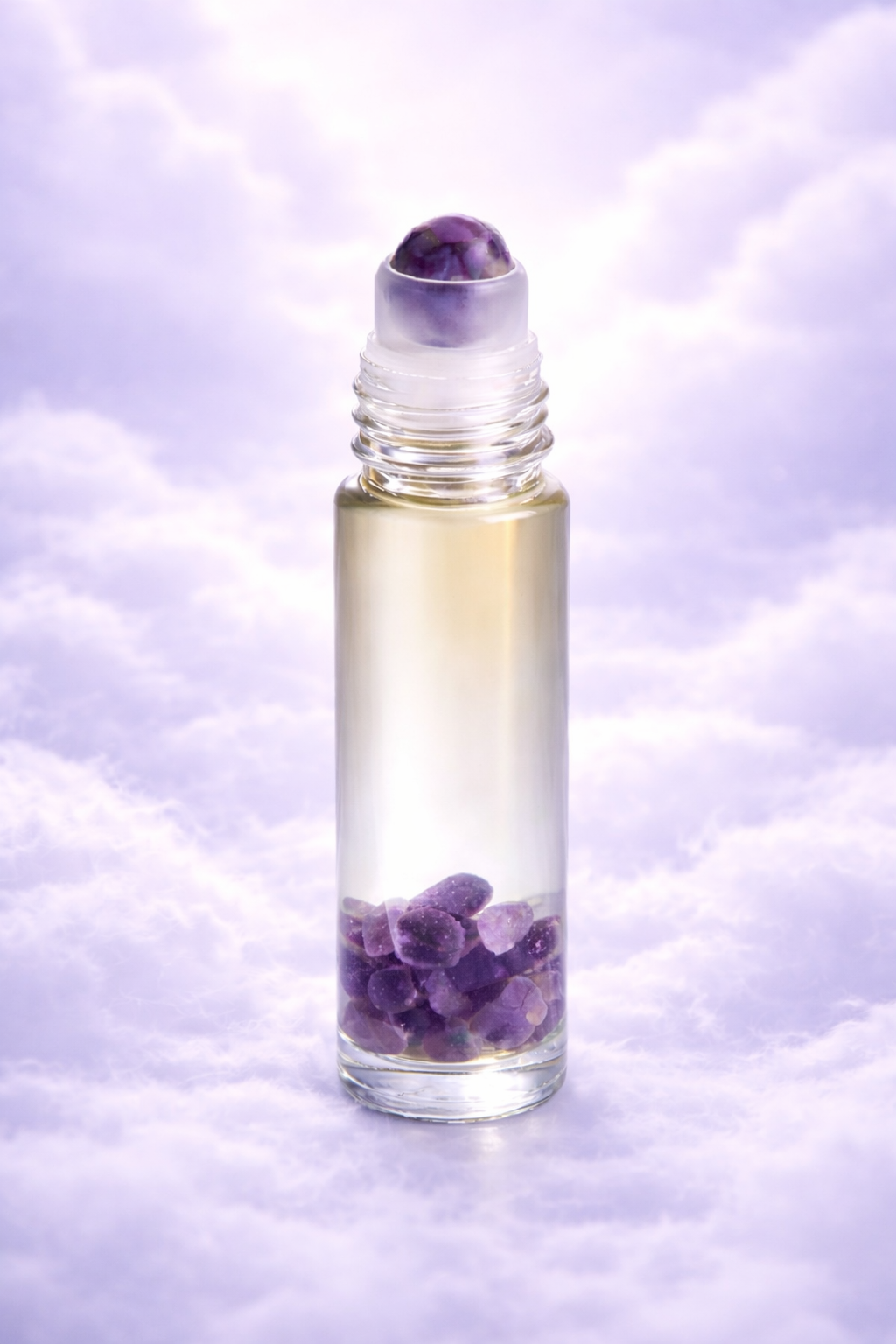 10ml clear glass roller bottle with amethyst toller ball & amethyst & clear quartz inside background is soft lilac fluffy clouds representing the blend midnight I that supports a rested sleep throughout the night 