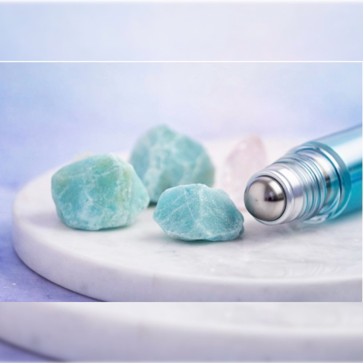 three crystals with a gradient roller bottle with a stainless steel rollerball tip lying there 